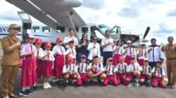 Pelajar SD Negeri Oreng Sambut Kedatangan Bupati dan Ketua TP PKK Murung Raya di Bandara Dirung